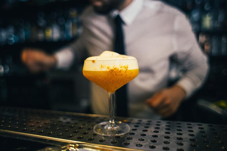 A cocktail being finished at the bar